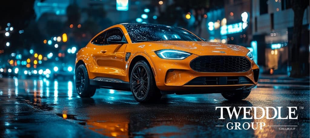 A sleek, vibrant orange sports SUV with a modern design is parked on a wet city street at night. The car's headlights and reflections from surrounding neon lights create a dynamic and futuristic atmosphere. The background features blurred city lights and buildings, enhancing the depth and contrast of the scene. Raindrops on the car's surface add texture and realism. This Generative AI Training Case Study featured image was produced by Tweddle Group using AI.